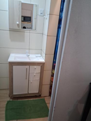 a bathroom with a sink and a mirror at Kitnet Avenida in Imbituba