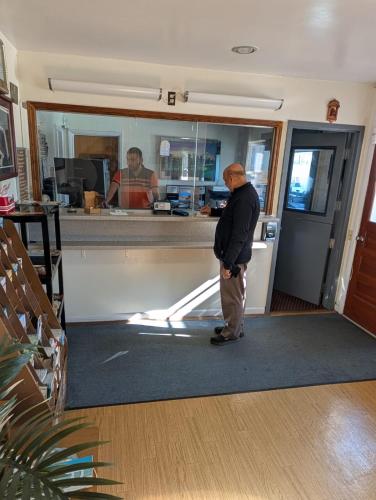 a man standing in front of a counter at Relax Inn in New Castle