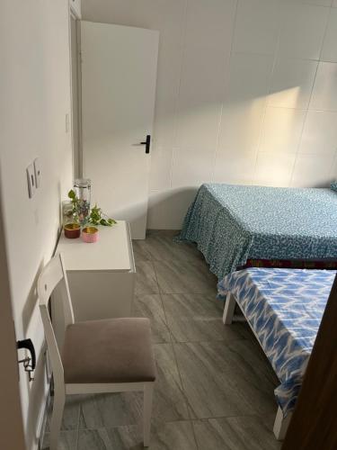 een kamer met 2 bedden en een tafel en een stoel bij Arembepe Vilage Duplex in Camaçari