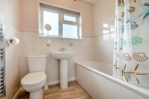a bathroom with a toilet and a sink and a tub at 3 Bed in St. Merryn oc-p00114 in Saint Merryn