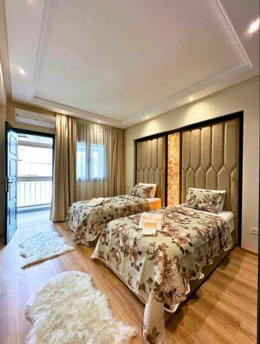 a bedroom with two beds and a large window at Noble Suite Luxury in Tangier