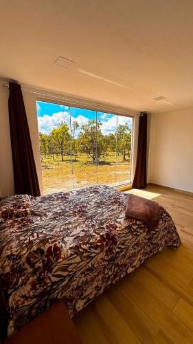a bedroom with a bed and a large window at Casa Bela Vista do Cerrado in Samambaia