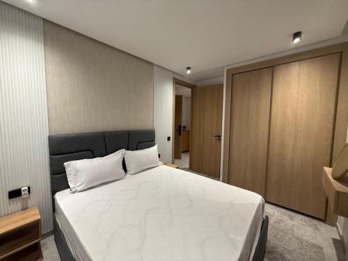 een slaapkamer met een groot wit bed en houten kasten bij Studio luxe Centre ville in Casablanca