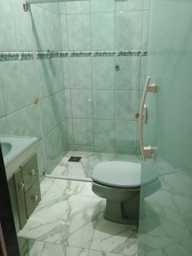 a white bathroom with a toilet and a shower at Regina in Cabo Frio