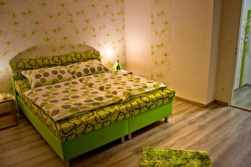 a bedroom with a green bed in a room at Motel Görföl in Veľký Meder