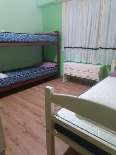 een kamer met twee stapelbedden en een raam bij Palermo calle 1 in Mar del Tuyú