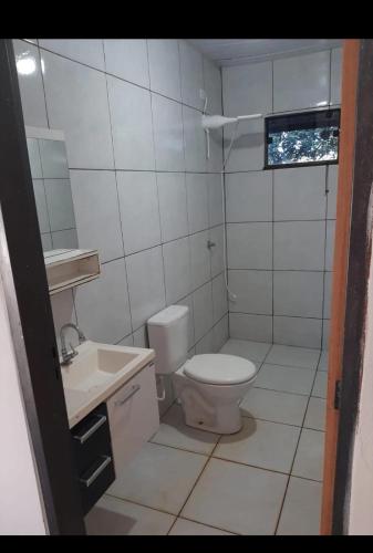 a white bathroom with a toilet and a sink at Casa indisponíve in Maracaju