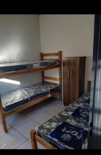 a room with two bunk beds and a cabinet at Casa indisponíve in Maracaju
