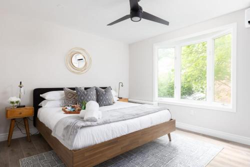 een slaapkamer met een groot bed met een plafondventilator bij New Modern Home in Old Town in Niagara on the Lake
