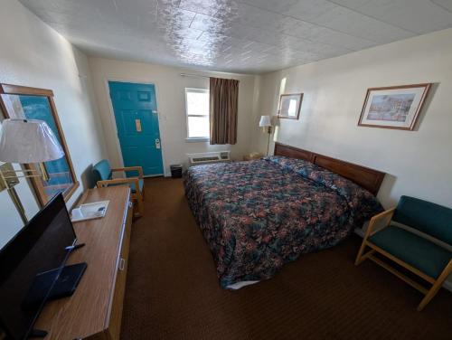 a hotel room with a bed and a desk at Relax Inn in New Castle