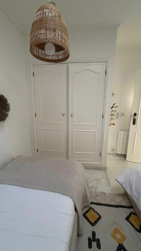 a white bedroom with a bed and a wicker ceiling at Praia da Barra Sweet Home in Gafanha da Nazaré