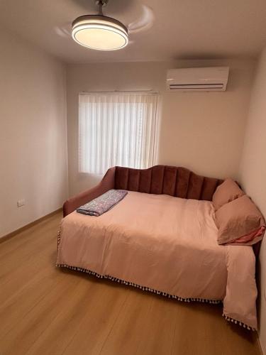 a bedroom with a couch in a room with a window at Residencia Flores in Hermosillo
