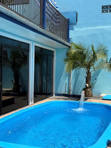 een groot blauw zwembad voor een gebouw bij Hotel Mais Lazer in Joinville