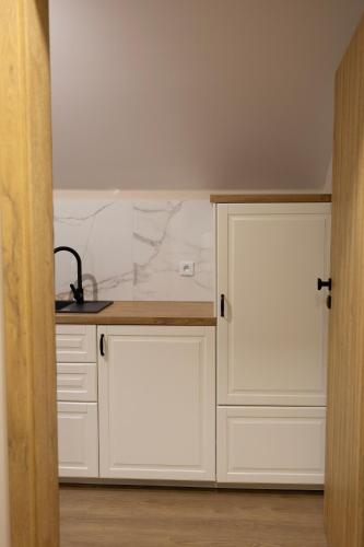 a kitchen with white cabinets and a counter at Apartamenty obok Suntago Park of Poland parking gratis in Wręcza