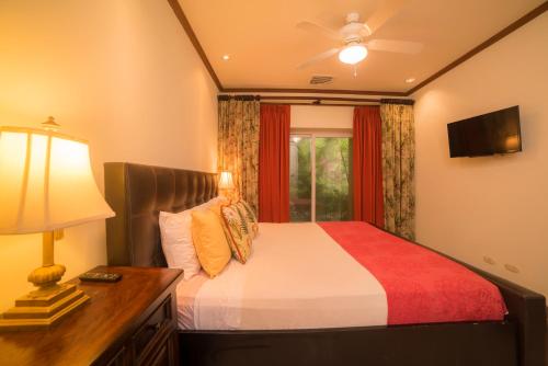 ein Schlafzimmer mit einem Bett mit einer Lampe und einem Fenster in der Unterkunft Veranda 8H 3 bdr Garden View in Los Suenos in Herradura