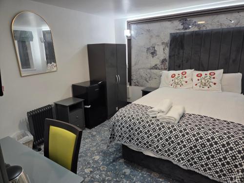 a bedroom with a bed and a table and a mirror at Ababeel Hotel in Birmingham