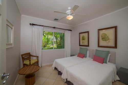 een slaapkamer met twee bedden en een raam bij Del Mar 4N 3 bdr Garden View in Los Suenos in Herradura