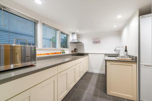 a large kitchen with white cabinets and a sink at BudgetWise Semi-Basement near Airport, UBC, Downtown in Vancouver in Vancouver