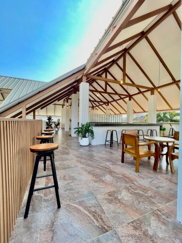 a patio with tables and benches and a roof at Secret Corner Boutique Stay in Chiang Rai