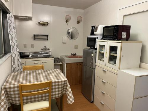 a small kitchen with a table and a microwave at 202basichostel in Osaka