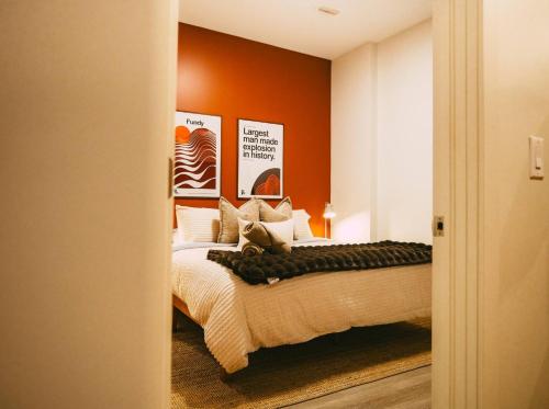 a bedroom with a bed with an orange wall at Historic 2BR suite in Halifax w Free Parking in Halifax