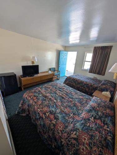 a hotel room with two beds and a television at Relax Inn in New Castle