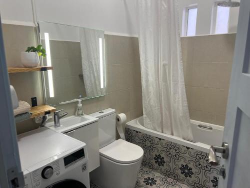 a bathroom with a toilet and a sink and a shower at Quinta das Rosas - Beach 500m away in Figueira da Foz