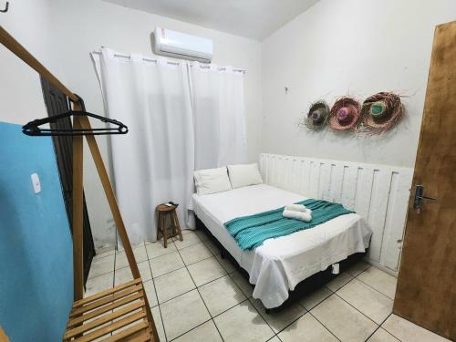 a small bed in a room with a window at Mini Hostel no centro de Tutoia in Tutóia