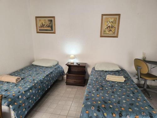 een kamer met 2 bedden, een bureau en een bureau bij SuÍte 4 Completa com Wi-Fi e Netflix in Jundiaí