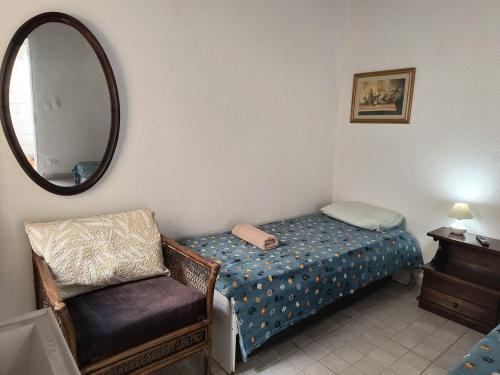 een slaapkamer met een bed, een stoel en een spiegel bij SuÍte 4 Completa com Wi-Fi e Netflix in Jundiaí