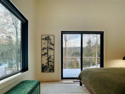 una camera da letto con un letto e una grande finestra di White Pine Chalet a Yulan