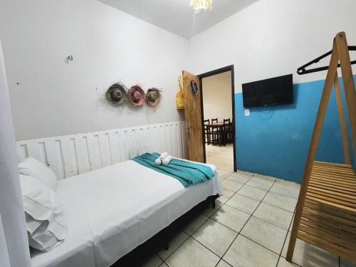 a bedroom with a bed and a tv in a room at Mini Hostel in Tutóia