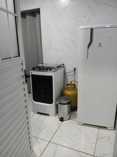 eine Küche mit Herd und Kühlschrank in der Unterkunft Kitnet na mata atlantica in Ubatuba