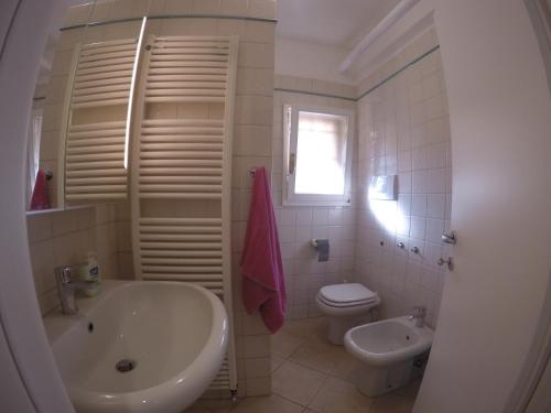 biała łazienka z umywalką i toaletą w obiekcie Procaccini Apartment w Bolonii