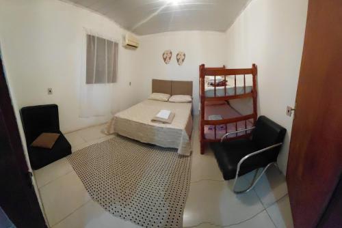 a small room with a bed and two chairs at Pousada do Coqueiro in São Gabriel