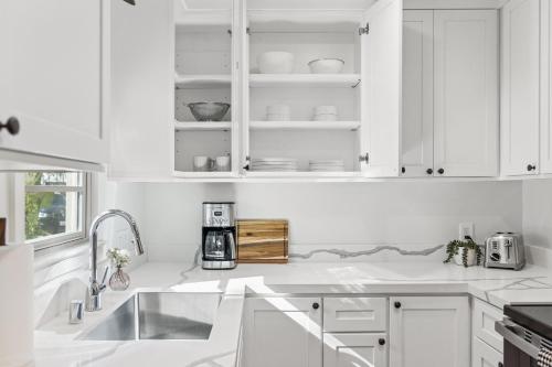 a white kitchen with white cabinets and a sink at Casa Yano by The Beach in Santa Barbara