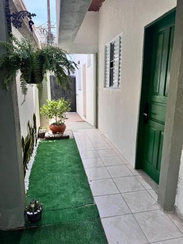 een lege gang met een groene deur en groen gras bij Suíte 2 Completa - Wi-Fi e Netflix in Jundiaí