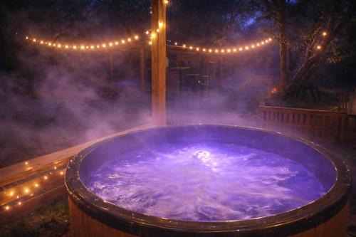 eine Whirlpool-Badewanne im Hof mit Licht in der Unterkunft Osada Brzeziny - 25 minut od Warszawy - sauna, balia z jacuzzi, basen, altana, grill, ogród, ognisko in Brzeziny