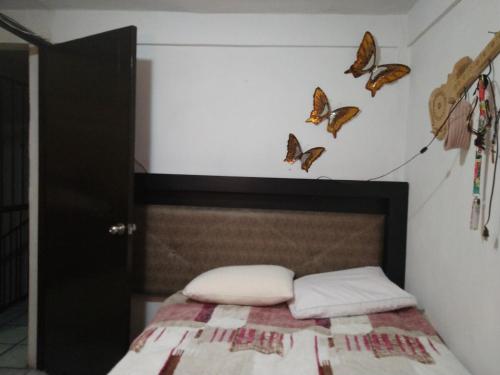 a bedroom with a bed with butterflies on the wall at Apartment 5 minutes away from AICM, GNP in Mexico City