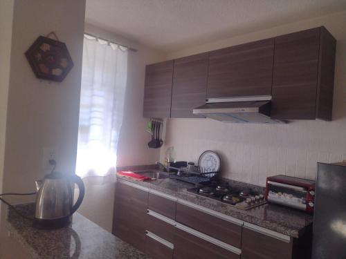 a kitchen with brown cabinets and a counter top at Apartment 5 minutes away from AICM, GNP in Mexico City