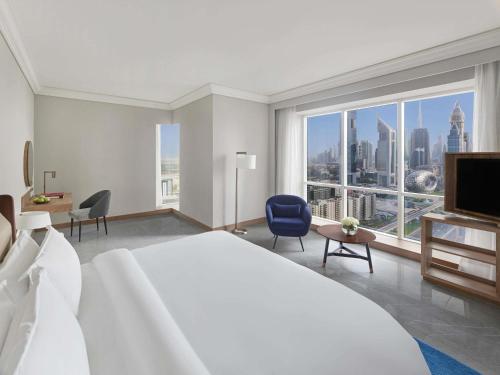 una camera da letto con un letto grande e una grande finestra di Fairmont Dubai a Dubai