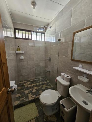 a bathroom with a toilet and a sink at Casa Burbujas in Puerto Jiménez
