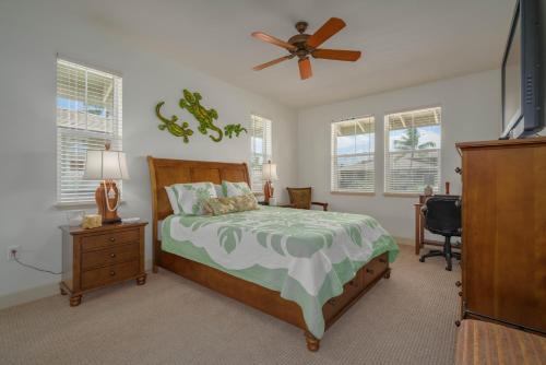 een slaapkamer met een bed en een plafondventilator bij Oceanfront Condo Halii Kai 14D in Waikoloa