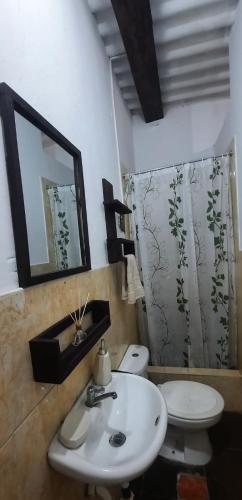 a bathroom with a sink and a toilet and a mirror at Sunset bed in Puerto Chicama