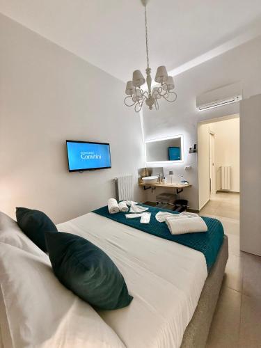a bedroom with a large bed with a chandelier at Foresteria del Genio - Luxury Suites & Urban Spa in Palermo