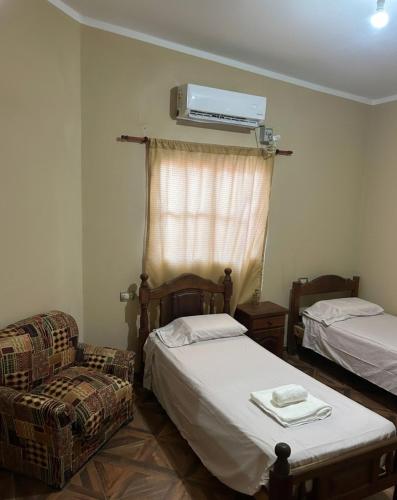 a room with two beds and a chair and a heater at Alojamiento Del Valle in San Fernando del Valle de Catamarca