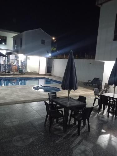 een tafel met een parasol naast een zwembad bij Narü extremo in Utica