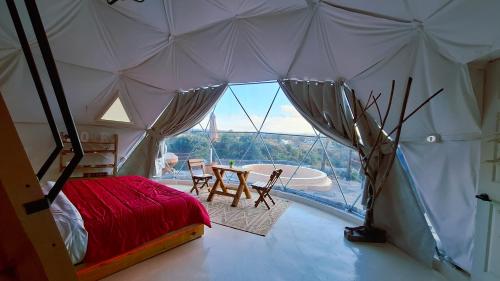 Zimmer mit einem Bett und einem Fenster in einem Zelt in der Unterkunft Rondo Glamping By GEstores in Pátzcuaro