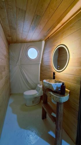 ein Badezimmer mit Toilette, Waschbecken und Spiegel in der Unterkunft Rondo Glamping By GEstores in Pátzcuaro