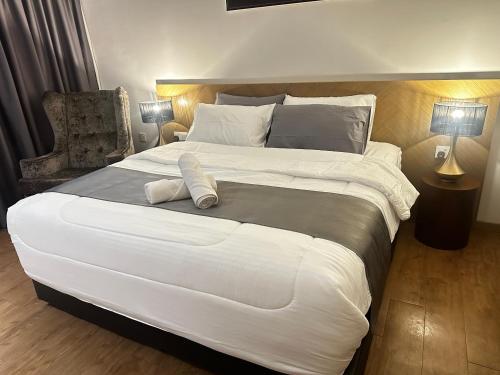 a large white bed in a bedroom with a chair at Nasai Retreat Studio in H Elite Design Building in Kota Bharu